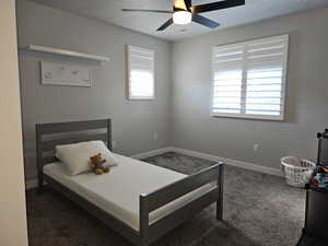 Carpeted bedroom with baseboards and ceiling fan