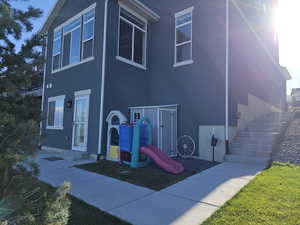View of back of home with stucco, outside entrance and stairway