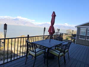 Deck with a water and mountain view and outdoor dining area