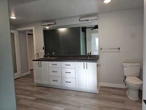 Basement bathroom featuring double vanity, recessed lighting, and LVP floors