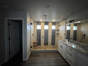 Bathroom with vanity, a textured ceiling, dark wood-style floors, and a stall shower