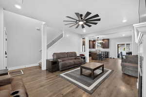 Living area featuring dark wood finished floors, stairs, recessed lighting, and a ceiling fan