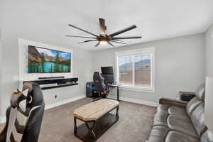 Second floor loft area featuring light carpet, a built-in entertainment center and a ceiling fan