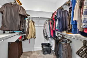 Primary walk-in closet featuring carpet floors