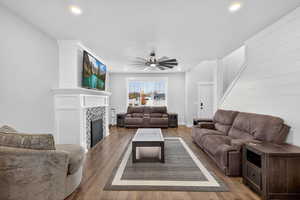 Living area with ceiling fan, wood-style floors, a tile fireplace, and recessed lighting