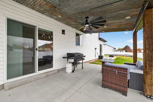 View of covered patio / terrace with a grill, ceiling fan, and an outdoor living space