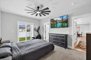 Primary bedroom with carpet floors, access to exterior, and a ceiling fan