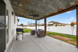 Fenced backyard with an outdoor living space, a patio area, a ceiling fan, area for grilling, and a residential view