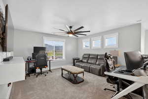 Second floor loft area featuring light carpet, a built-in entertainment center and a ceiling fan