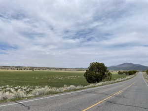 View of asphalt road featuring a view of countryside and a mountain view