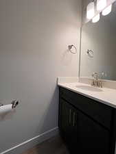 Bathroom featuring vanity and dark wood-style flooring
