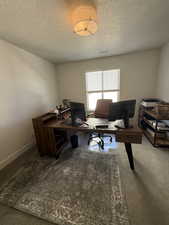Office area with a textured ceiling and baseboards