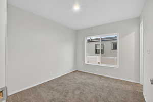 Carpeted spare room with baseboards