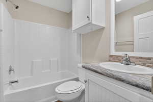 Full bath featuring vanity,  shower combination, and backsplash