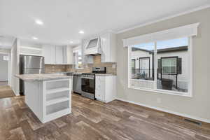 Kitchen featuring open shelves, backsplash, white cabinetry, appliances with stainless steel finishes, and ornamental molding