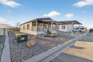 Manufactured / mobile home featuring a porch and an attached carport