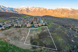 Aerial perspective of suburban area with property boundaries highlighted and a mountain backdrop