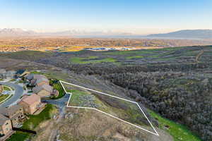 Aerial view of property's location featuring property boundaries highlighted, a mountain backdrop, and nearby suburban area