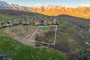 Aerial perspective of suburban area with property boundaries highlighted and a mountain backdrop