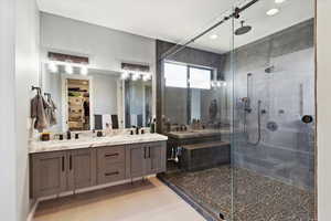 Bathroom with a walk in closet, a stall shower, double vanity, light tile patterned flooring, and recessed lighting