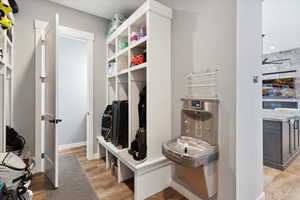 Mudroom featuring light wood-type flooring and baseboards