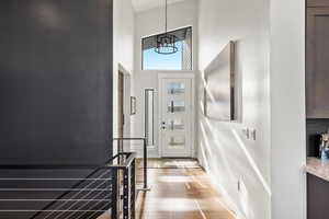 Foyer entrance featuring a towering ceiling and light wood-type flooring