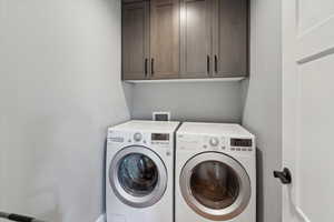 Washroom featuring cabinet space and washing machine and clothes dryer