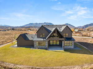 Rear view of property with stone siding, a standing seam roof, a metal roof, and a mountain view