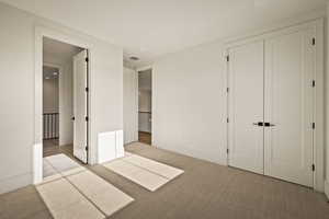 Unfurnished bedroom featuring carpet and a closet