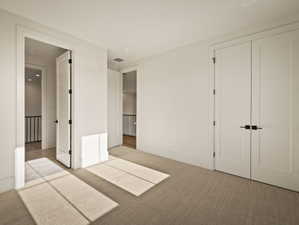 Unfurnished bedroom featuring carpet and a closet