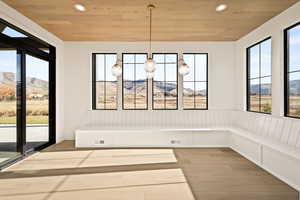 Unfurnished dining area featuring a mountain view, light wood finished floors, wood ceiling, and recessed lighting