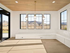 Unfurnished dining area featuring a mountain view, light wood finished floors, wood ceiling, and recessed lighting