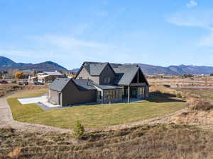 View of front facade featuring a standing seam roof, stone siding, a mountain view, and a metal roof