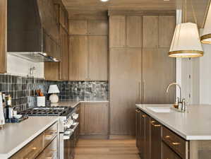 Kitchen with wooden ceiling, recessed lighting, premium range hood, stainless steel range, and light wood finished floors