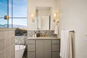 Full bathroom with vanity, a mountain view, a freestanding tub, and backsplash