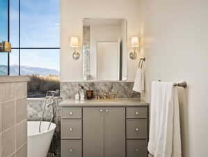 Full bathroom with vanity, a mountain view, a freestanding tub, and backsplash