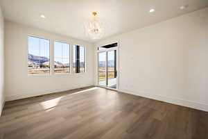 Unfurnished room with a mountain view, a chandelier, light wood-style flooring, and recessed lighting