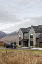 View of front of property featuring stone siding, a standing seam roof, and a mountain view