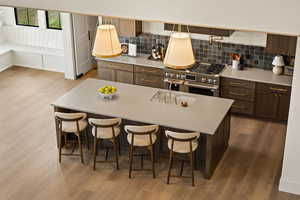 Kitchen featuring light wood finished floors, dark brown cabinets, and range with two ovens