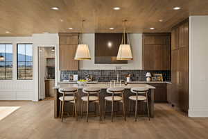 Kitchen featuring a breakfast bar, a mountain view, decorative light fixtures, recessed lighting, and light wood-type flooring