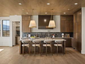 Kitchen featuring a breakfast bar, a mountain view, decorative light fixtures, recessed lighting, and light wood-type flooring