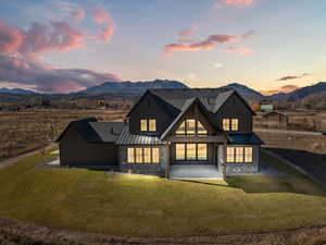 Back of property featuring a standing seam roof, a metal roof, and stone siding