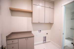 Laundry room featuring washer hookup, cabinet space, hookup for an electric dryer, and a wall unit AC