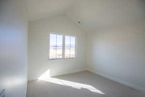 Carpeted spare room with vaulted ceiling and a mountain view