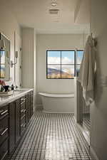 Bathroom with vanity, a soaking tub, and a textured ceiling