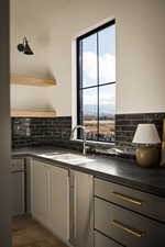 Kitchen with open shelves, gray cabinetry, and dark wood-type flooring