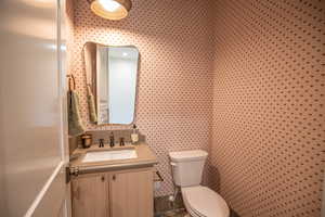 Half bathroom with vanity and toilet