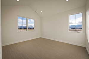 Empty room with a mountain view, carpet floors, recessed lighting, and lofted ceiling