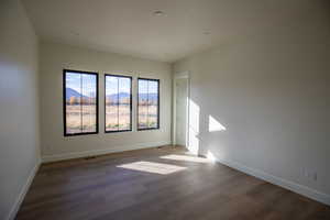 Empty room with a mountain view and wood finished floors