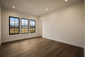 Unfurnished room featuring dark wood-style floors and recessed lighting